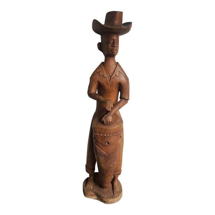 Hand-Carved Wood Folk Musician Sculpture 51.25 Inch Tall Boho Floor Art: Hand-Carved Wood Folk Musician Sculpture 51.25 Inch Tall Boho Floor Art This monumental hand-carved sculpture depicts a dynamic musician figure wearing a folk or cowboy hat and playing a large drum. C