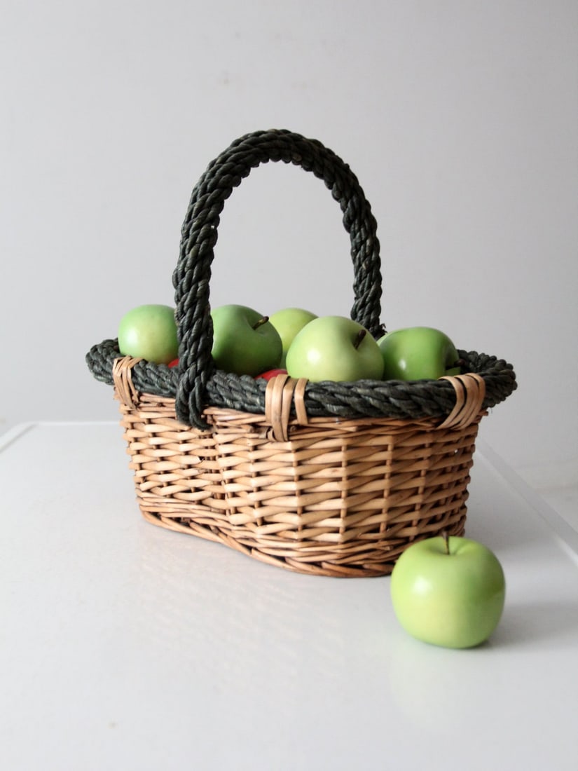 Handcrafted Vintage Woven Basket with Dark Green Rope Handle: Handcrafted Vintage Woven Basket with Dark Green Rope Handle This vintage woven basket showcases a natural design, complemented by a braided dark green rope handle that adds a striking contrast. The w