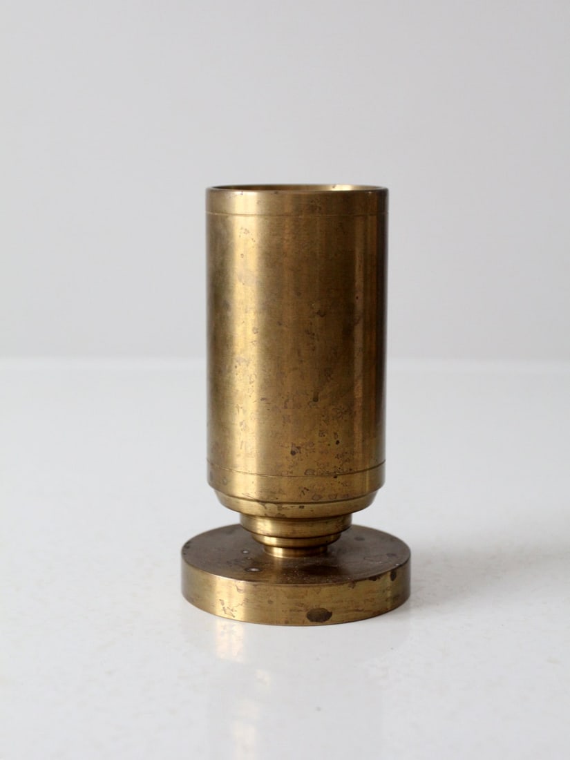 Brass Trench Art Vase Vintage Shell Casing 6 Inch: Brass Trench Art Vase Vintage Shell Casing 6 Inch This vintage trench art vase showcases a unique design crafted from a brass shell casing, featuring clean lines and a pedestal base. It is in good con