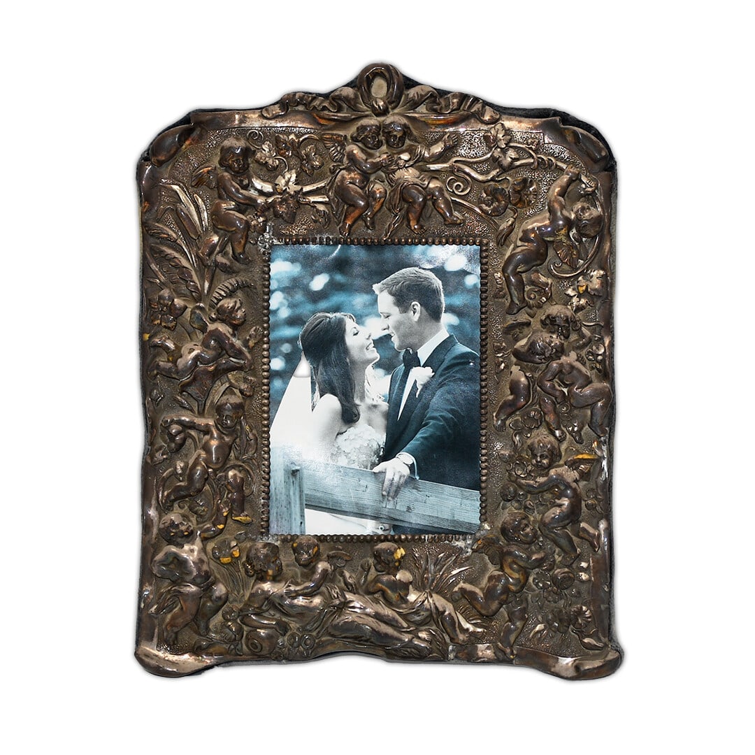 Art Deco Silver Plated Picture Frame with Angel Motifs 9x5: Art Deco Silver Plated Picture Frame with Angel Motifs 9x5 This exquisite Art Deco silver plated picture frame features a charming design with angels adorning the borders. It is designed to hold a 9x5