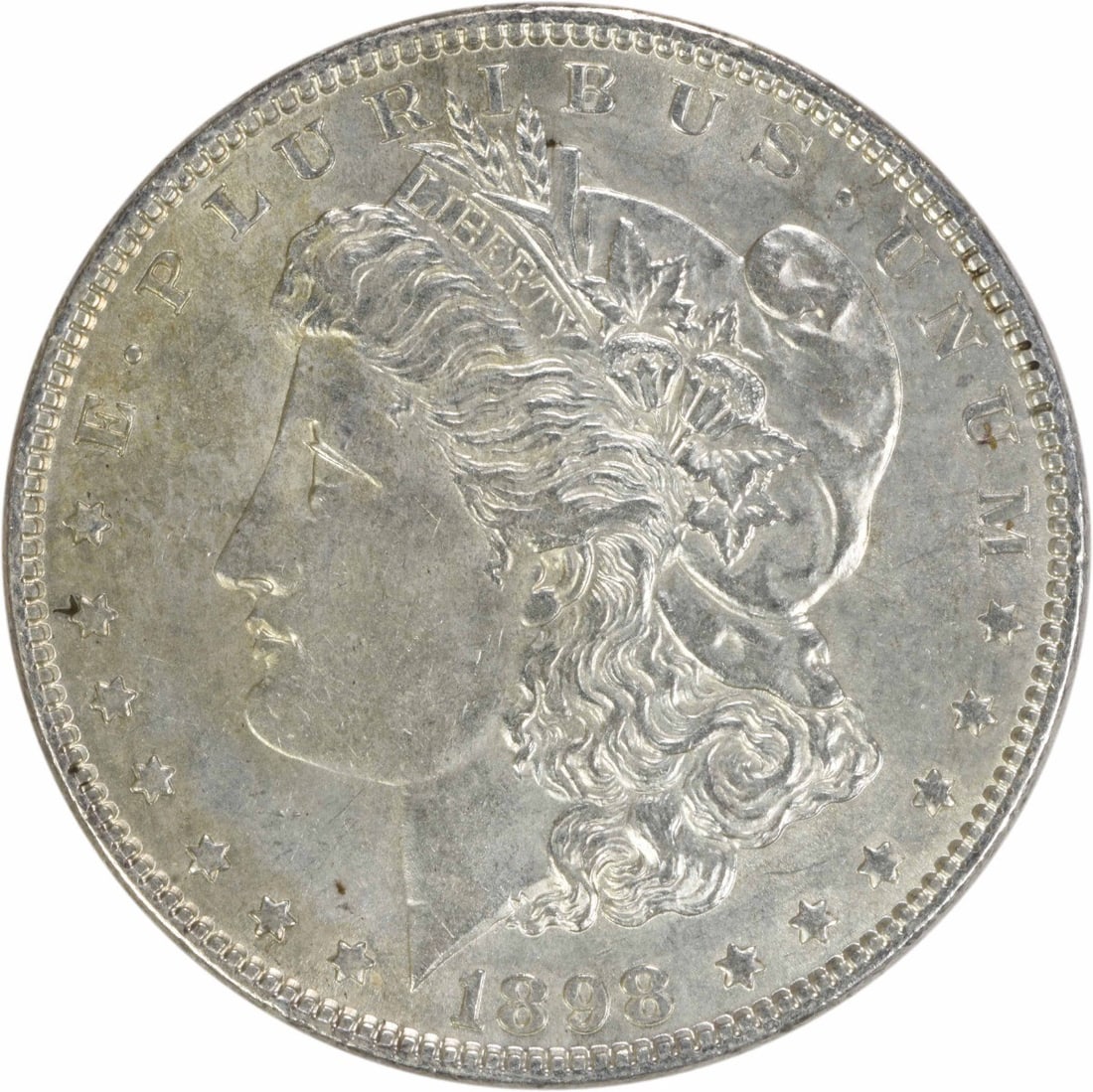 1898 Morgan Silver Dollar AU Uncertified 90% Silver Coin: 1898 Morgan Silver Dollar AU Uncertified 90% Silver Coin This 1898 Morgan Silver Dollar is an exquisite piece of numismatic history, featuring a stunning design by George T. Morgan. The coin is in AU