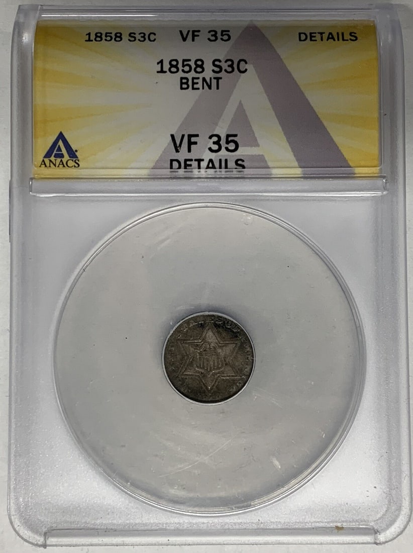1858 United States Three Cent Silver Coin Certified by ANACS VF 35 Bent: 1858 United States Three Cent Silver Coin Certified by ANACS VF 35 Bent This 1858 Three Cent Silver coin from the United States is certified by ANACS with a grade of VF 35 Details and noted as bent. T