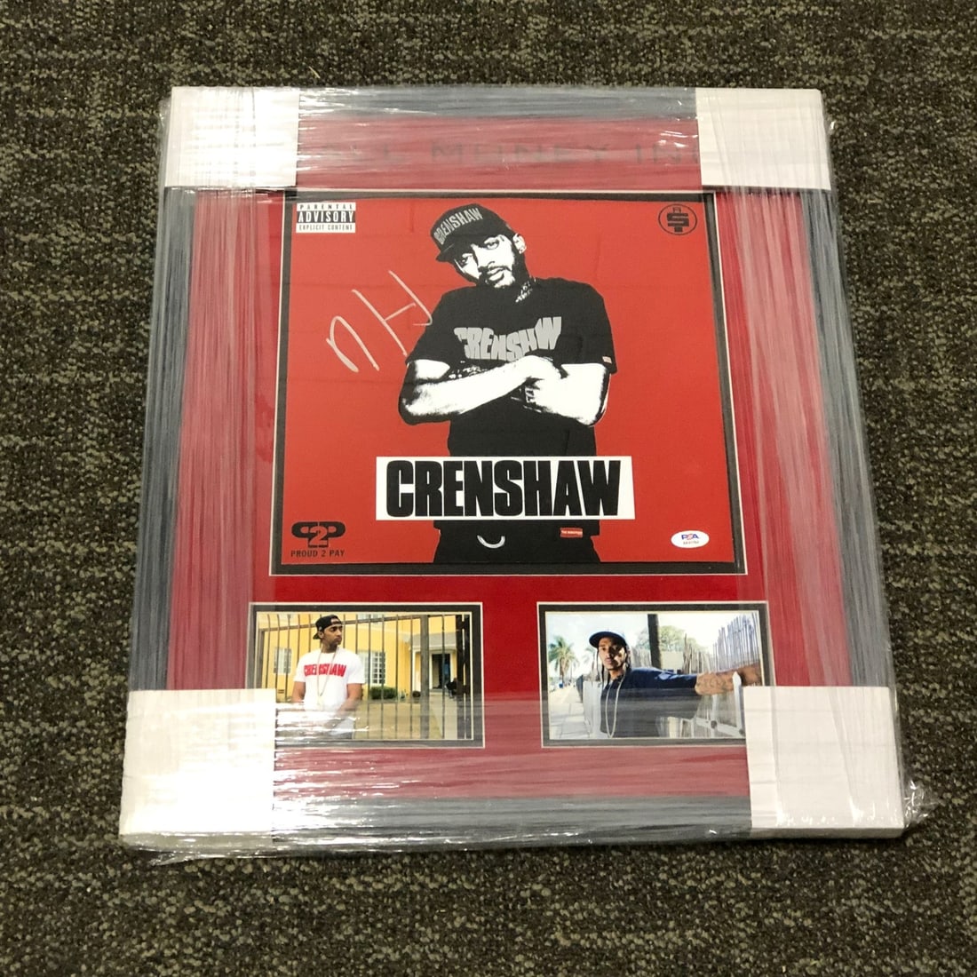 Nipsey Hussle Autographed 19x23 Framed Photo with PSA/DNA LOA: Nipsey Hussle Autographed 19x23 Framed Photo with PSA/DNA LOA This custom framed and matted photo features an authentic autograph by the late Nipsey Hussle. Measuring 19x23 inches, the photograph is a