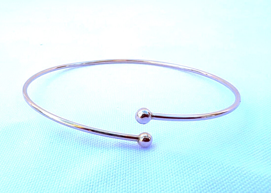 Tiffany & Co 14K Yellow Gold Flexible Bangle Bracelet: Tiffany & Co 14K Yellow Gold Flexible Bangle Bracelet This exquisite Tiffany & Co. 14K yellow gold bangle bracelet is a perfect blend of elegance and craftsmanship. Designed in a classic bangle style,