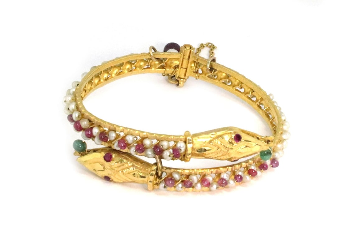Estate 21k Gold Double Snake Head Bracelet with Ruby Emerald Pearls: Estate 21k Gold Double Snake Head Bracelet with Ruby Emerald Pearls This exquisite Estate bracelet is crafted from 21k yellow gold and features a striking double snake head design in a bypass style. T