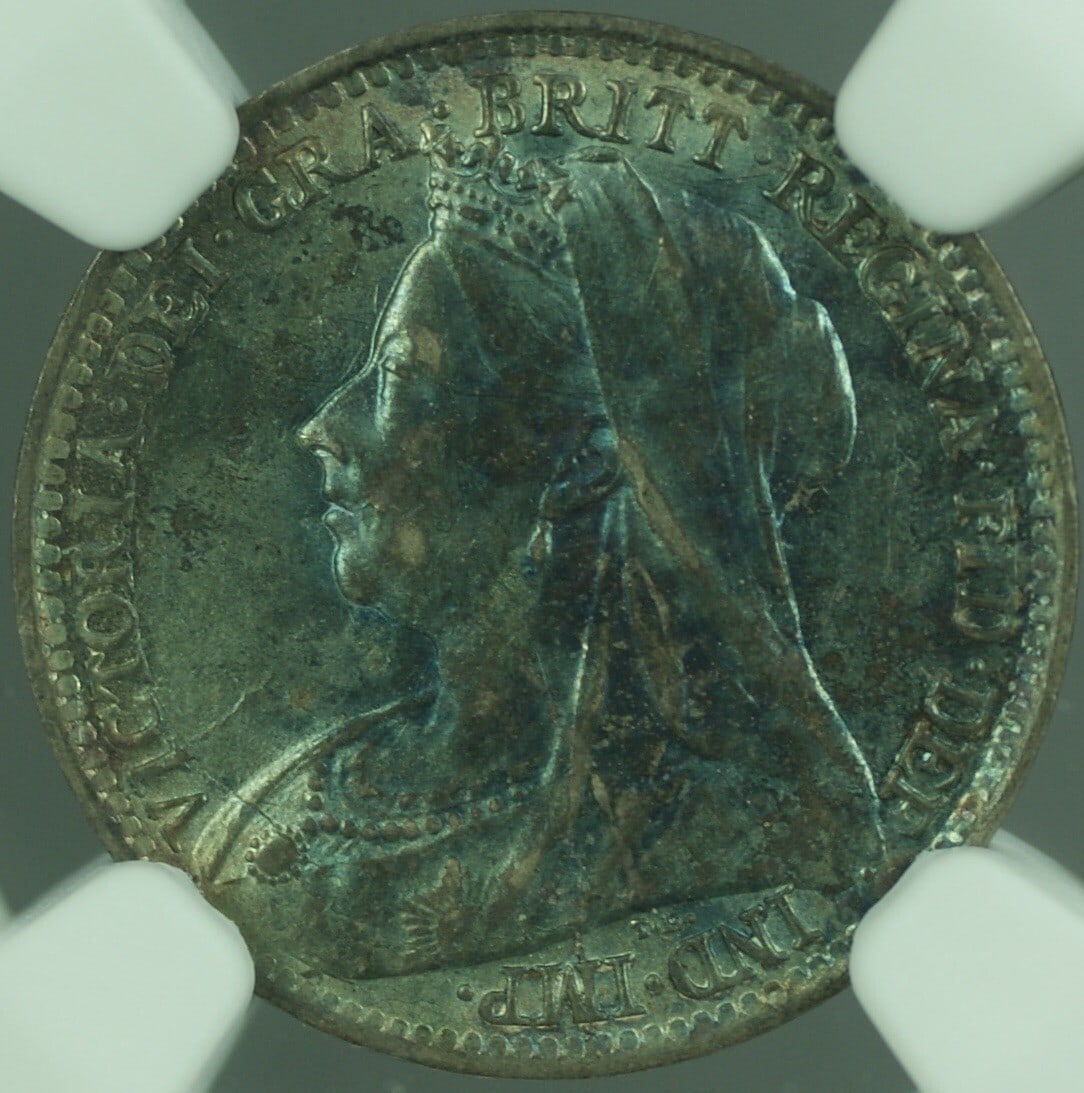 1896 United Kingdom Maundy 3 Pence NGC AU 58 with Attractive Toning: 1896 United Kingdom Maundy 3 Pence NGC AU 58 with Attractive Toning This 1896 Great Britain 3 Pence Maundy coin features attractive toning and is certified by NGC with an AU 58 grade. It is a pre-owne