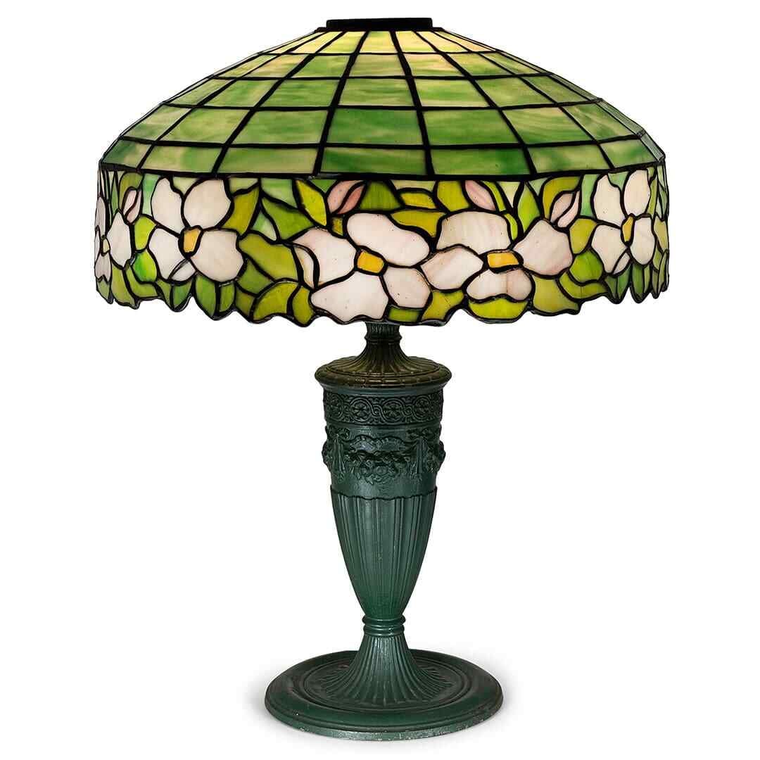 Art Nouveau Leaded Glass Lamp With Floral Motif By Edward Miller & Co.: Art Nouveau Leaded Glass Lamp With Floral Motif By Edward Miller & Co. This early 20th-century Art Nouveau table lamp by Edward Miller & Co. features a vibrant stained glass floral shade and an antiqu
