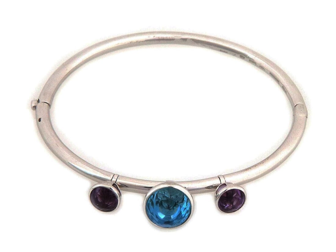 Gerrard 18k White Gold Bangle Bracelet With Blue Topaz Amethyst Charms: Gerrard 18k White Gold Bangle Bracelet With Blue Topaz Amethyst Charms This sophisticated 18k white gold bangle bracelet features three dangle charms set with vibrant blue topaz and purple amethyst ge