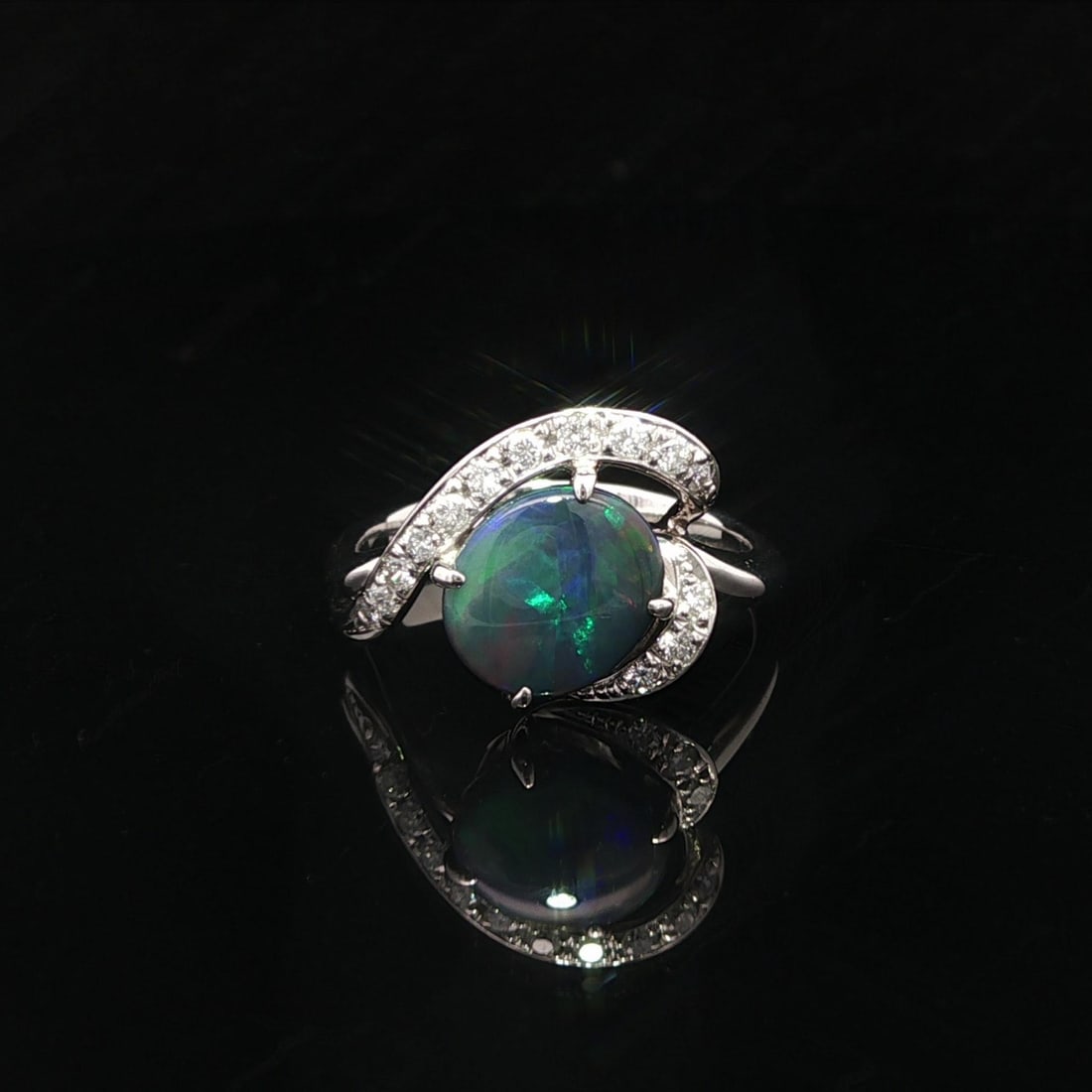 Platinum 1.67ct Black Opal Diamond Cocktail Ring: Platinum 1.67ct Black Opal Diamond Cocktail Ring This exquisite cocktail ring showcases a stunning 1.46ct natural black opal in an elegant oval cabochon cut, securely prong set to highlight its captiv