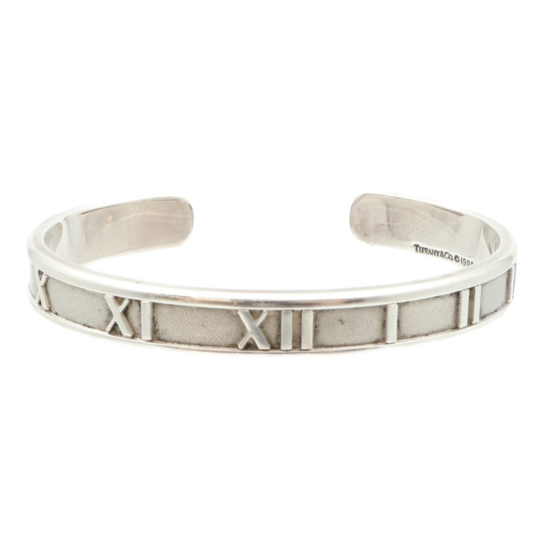 Atlas Collection 925 Silver Bangle Bracelet by Tiffany & Co.: Atlas Collection 925 Silver Bangle Bracelet by Tiffany & Co. This Tiffany & Co. Atlas bangle bracelet is crafted from 925 sterling silver and features a sleek design with no main stone. The piece show