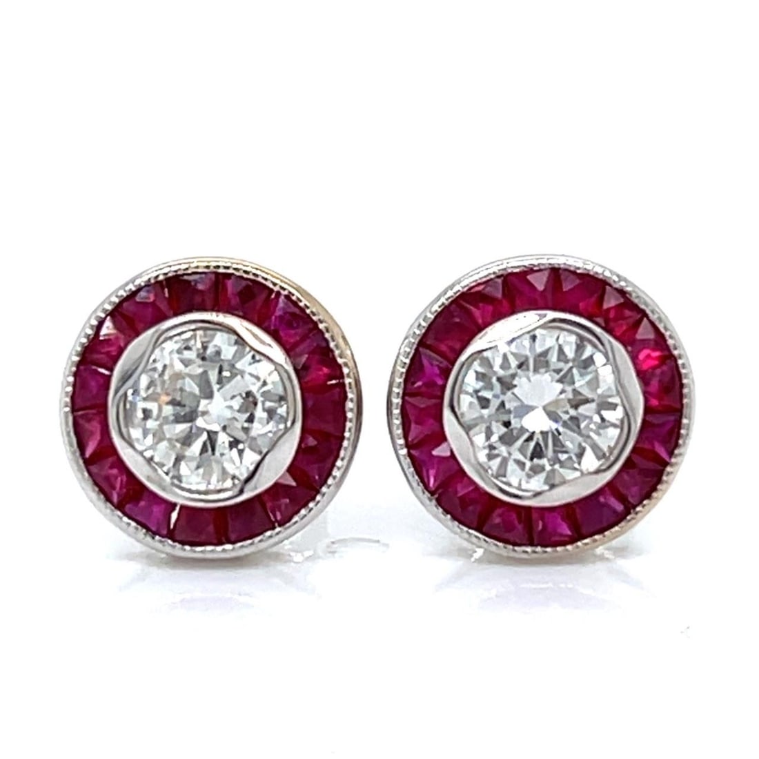 Diamond and Ruby Stud Earrings in 18K White Gold: Diamond and Ruby Stud Earrings in 18K White Gold These stud earrings are crafted from 18K white gold and feature two diamonds with a total weight of 0.85 carats in H-I color and VS1-SI1 clarity, compl