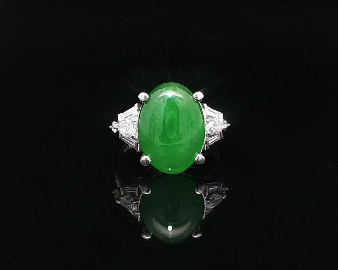 Platinum GIA Certified 5.57ct Green Burma Jade Diamond Accent Ring: Platinum GIA Certified 5.57ct Green Burma Jade Diamond Accent Ring This exquisite cocktail ring showcases a stunning 5.11ct natural A jade gemstone, expertly cut into an oval double cabochon shape. Th