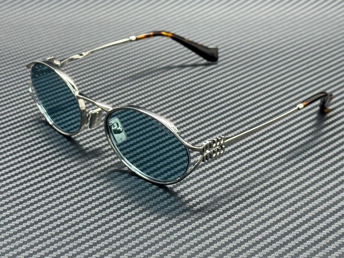 Miu Miu MU 52YS Silver and Light Blue 54mm Women's Sunglasses: Miu Miu MU 52YS Silver and Light Blue 54mm Women's Sunglasses These Miu Miu MU 52YS 1BC20R women's sunglasses feature a silver frame with light blue lenses. Made in Italy, the sunglasses have a 54 mm