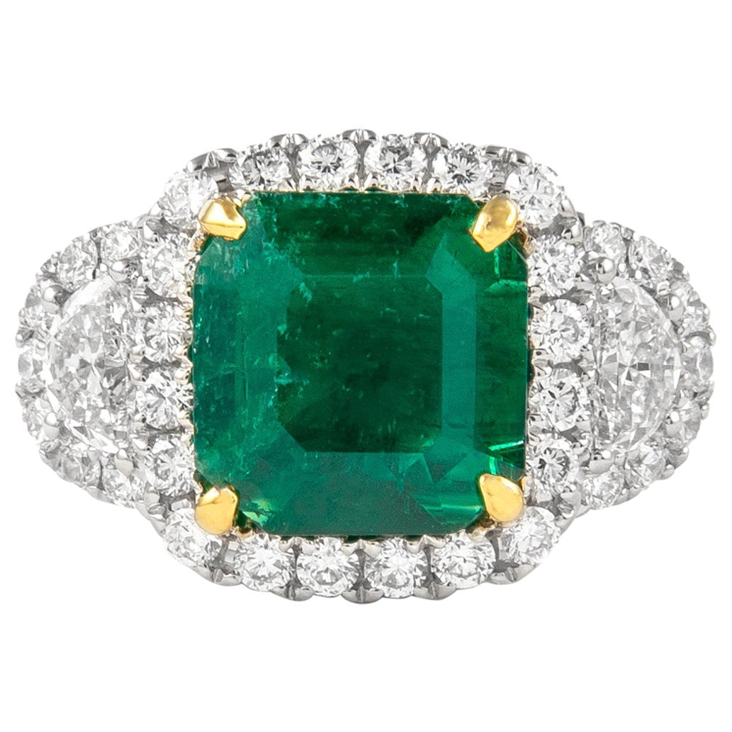 3.26ct Emerald Diamond Halo Ring 18k Gold: 3.26ct Emerald Diamond Halo Ring 18k Gold This exquisite three stone halo ring features a stunning 3.26 ct emerald at its center, beautifully complemented by two half moon diamonds. Crafted from 18k w