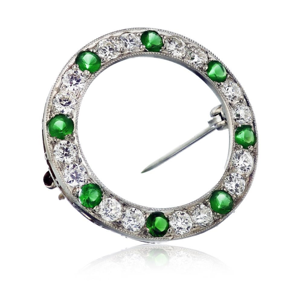 Spaulding Art Deco Platinum Brooch with Green Tsavorite and 2 Carats of Diamonds: Spaulding Art Deco Platinum Brooch with Green Tsavorite and 2 Carats of Diamonds This exquisite brooch showcases an Art Deco design and is crafted from high-quality platinum. Adorned with vibrant gree