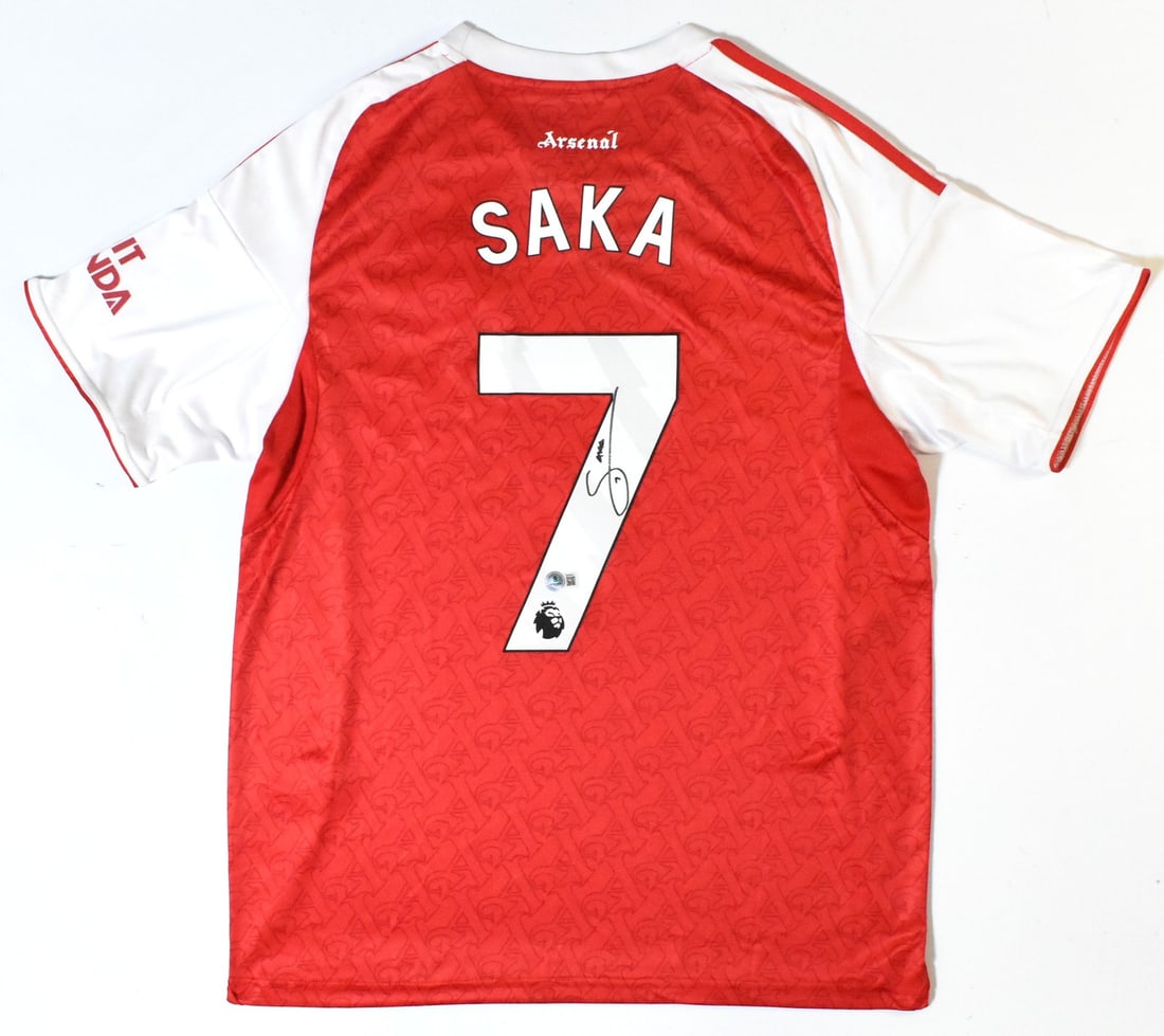 Arsenal FC Home Jersey Signed by Saka with Beckett Hologram: Arsenal FC Home Jersey Signed by Saka with Beckett Hologram This is a pre-owned Arsenal FC home soccer jersey, autographed by player Saka and featuring the number 7. The jersey comes with a Beckett ho