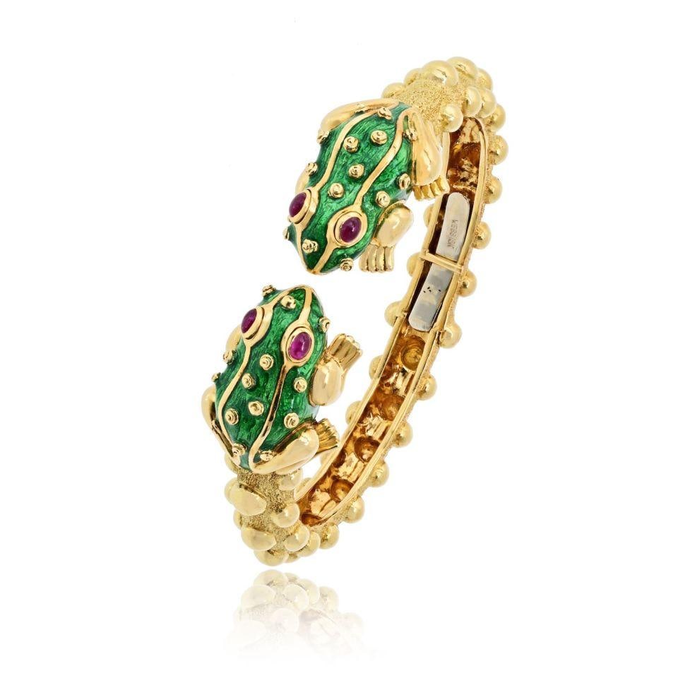 18K Yellow Gold Bangle by David Webb: 18K Yellow Gold Bangle by David Webb This pre-owned bangle bracelet by David Webb is crafted from 18K yellow gold and features a substantial design. It has a total weight of 57.9 grams. Specifications