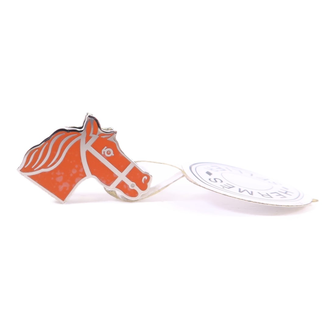 Silver Tone Scarf Ring with Orange Accent by Hermes: Silver Tone Scarf Ring with Orange Accent by Hermes This Hermes scarf ring features a sleek silver color with orange accents, crafted from metal. It is a versatile accessory designed to complement a v