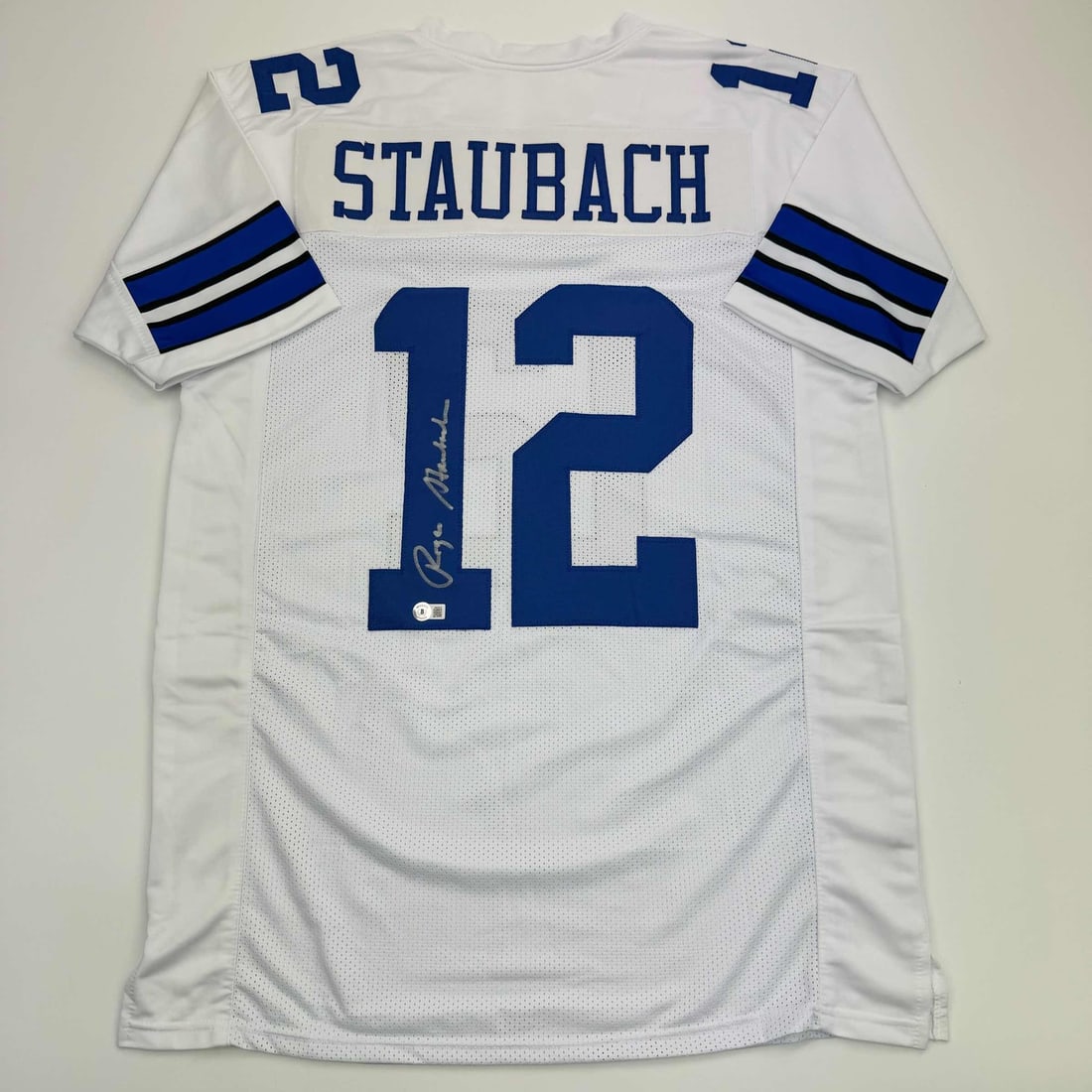 Roger Staubach Signed Custom Dallas Football Jersey Beckett Authenticated: Roger Staubach Signed Custom Dallas Football Jersey Beckett Authenticated This is a custom Dallas white football jersey autographed by Roger Staubach. The jersey is intended as a collectible and is no