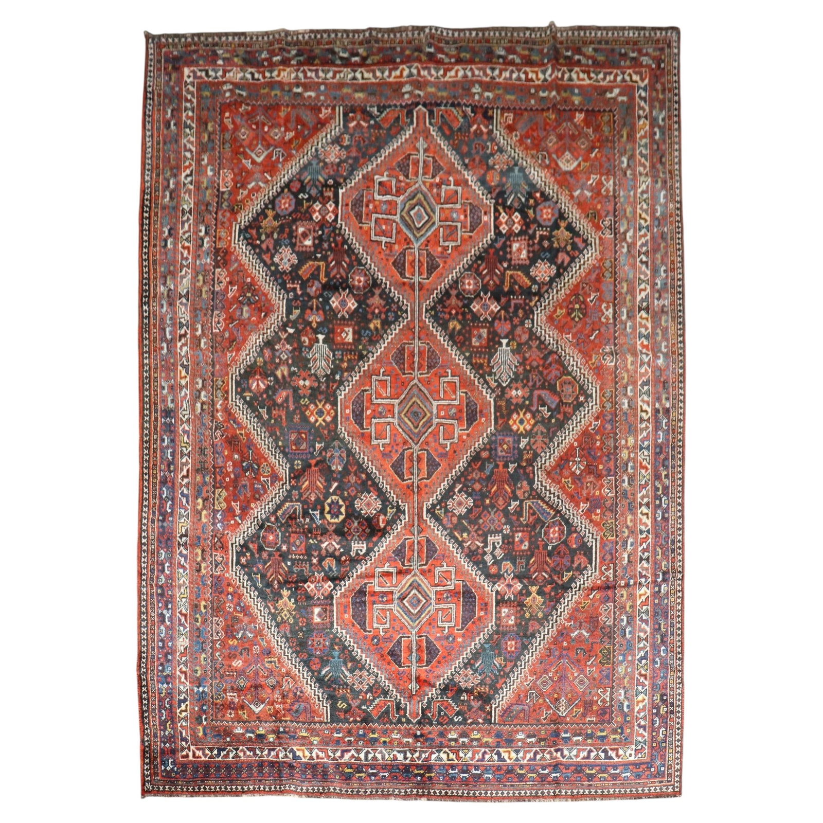 Early 20th Century Persian Shiraz Wool Rug 7'7" x 10'2": Early 20th Century Persian Shiraz Wool Rug 7'7" x 10'2" This early 20th-century Shiraz rug from Iran features a striking jewel-toned geometric tribal design. Hand-woven from wool, it showcases the cra