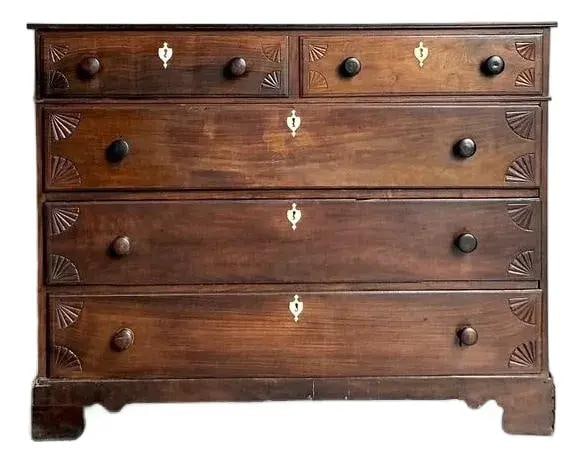 Mahogany Chest of Drawers With Carved Details and Bone Inlay Escutcheons: Mahogany Chest of Drawers With Carved Details and Bone Inlay Escutcheons This antique British colonial chest of drawers, likely from the mid-Victorian or late Georgian era, is crafted from rich mahoga