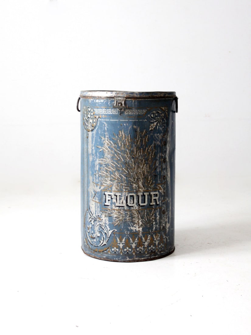 Vintage 19th Century Blue Tin Flour Bin with Wheat Design: Vintage 19th Century Blue Tin Flour Bin with Wheat Design This antique metal flour bin, dating back to the late 19th century, showcases a charming decorative wheat design on its large blue tin surface