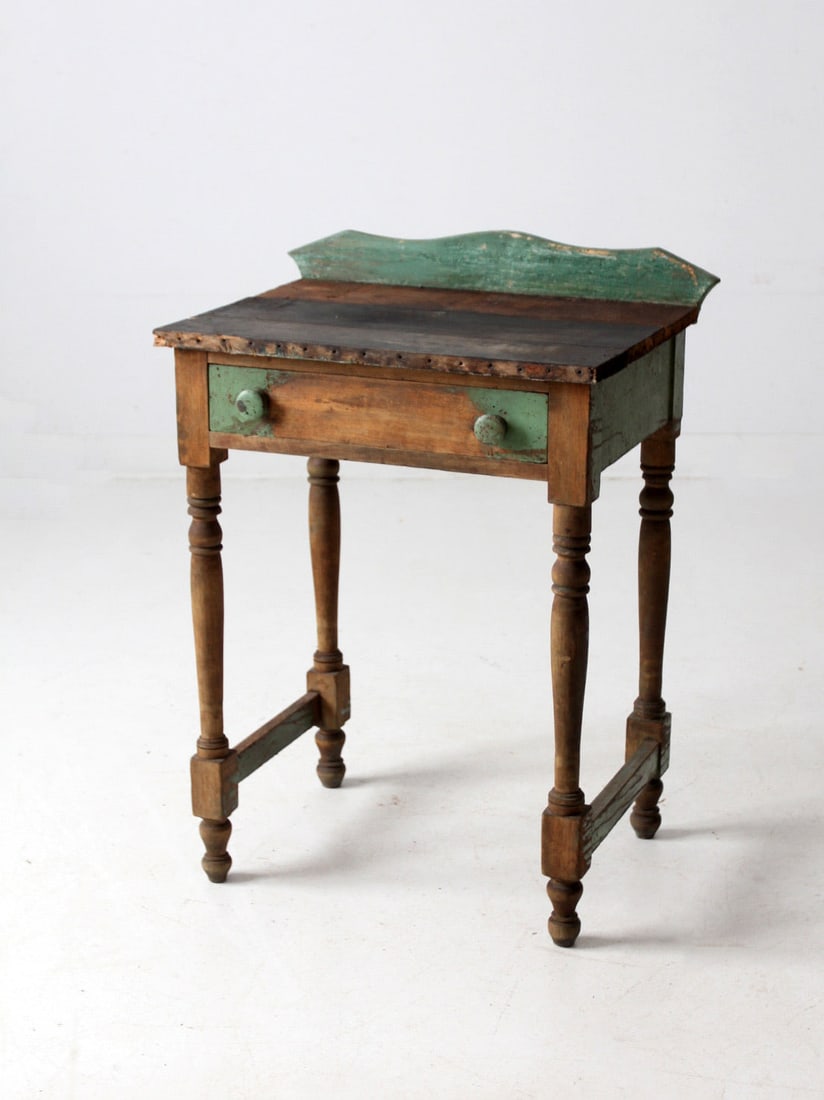 Rustic Antique Farmhouse Side Table with Drawer and Aged Green Finish: Rustic Antique Farmhouse Side Table with Drawer and Aged Green Finish This antique farmhouse side table embodies rustic charm and timeless function, making it a versatile addition to any space. It fea