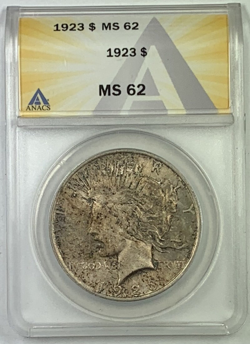 1923 Silver Peace Dollar Graded MS 62 by ANACS with Toned Finish: 1923 Silver Peace Dollar Graded MS 62 by ANACS with Toned Finish This 1923 Peace Silver Dollar is a United States $1 coin composed of silver. Graded MS 62 by ANACS, it is an uncirculated coin with ton