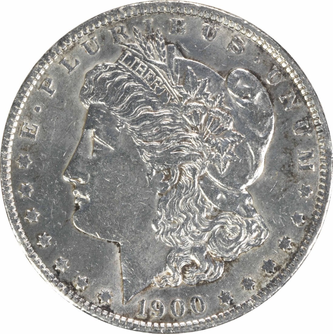 1900-O Morgan Silver Dollar AU Uncertified 90% Silver Coin: 1900-O Morgan Silver Dollar AU Uncertified 90% Silver Coin This 1900-O Morgan Silver Dollar is a remarkable piece of numismatic history, showcasing the artistry of designer George T. Morgan. With a gr