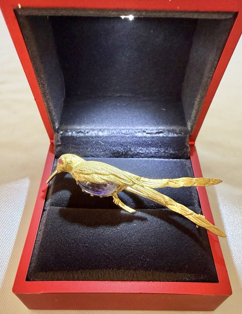 18k Yellow Gold French Hummingbird Brooch with Amethyst and Ruby in Box: 18k Yellow Gold French Hummingbird Brooch with Amethyst and Ruby in Box This exquisite French hummingbird brooch is crafted from 18k yellow gold and features an amethyst and ruby accent. Showcasing fi