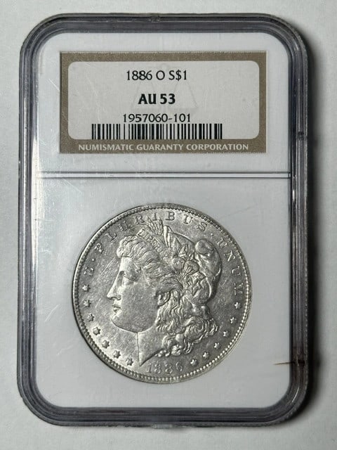 NGC Graded AU 53 1886 O Silver Morgan Dollar Coin: NGC Graded AU 53 1886 O Silver Morgan Dollar Coin This 1886 O Morgan Silver Dollar is graded AU-53 by NGC. Minted in New Orleans, it is composed of silver and is a circulated coin from the United Stat