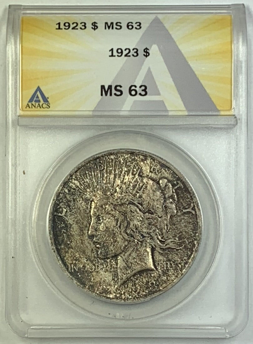 ANACS MS 63 Graded 1923 Peace Silver Dollar with Toned Finish: ANACS MS 63 Graded 1923 Peace Silver Dollar with Toned Finish This is a 1923 Peace Silver $1 Dollar Coin, featuring attractive natural toning. The coin is graded MS 63 by ANACS, indicating an uncircul