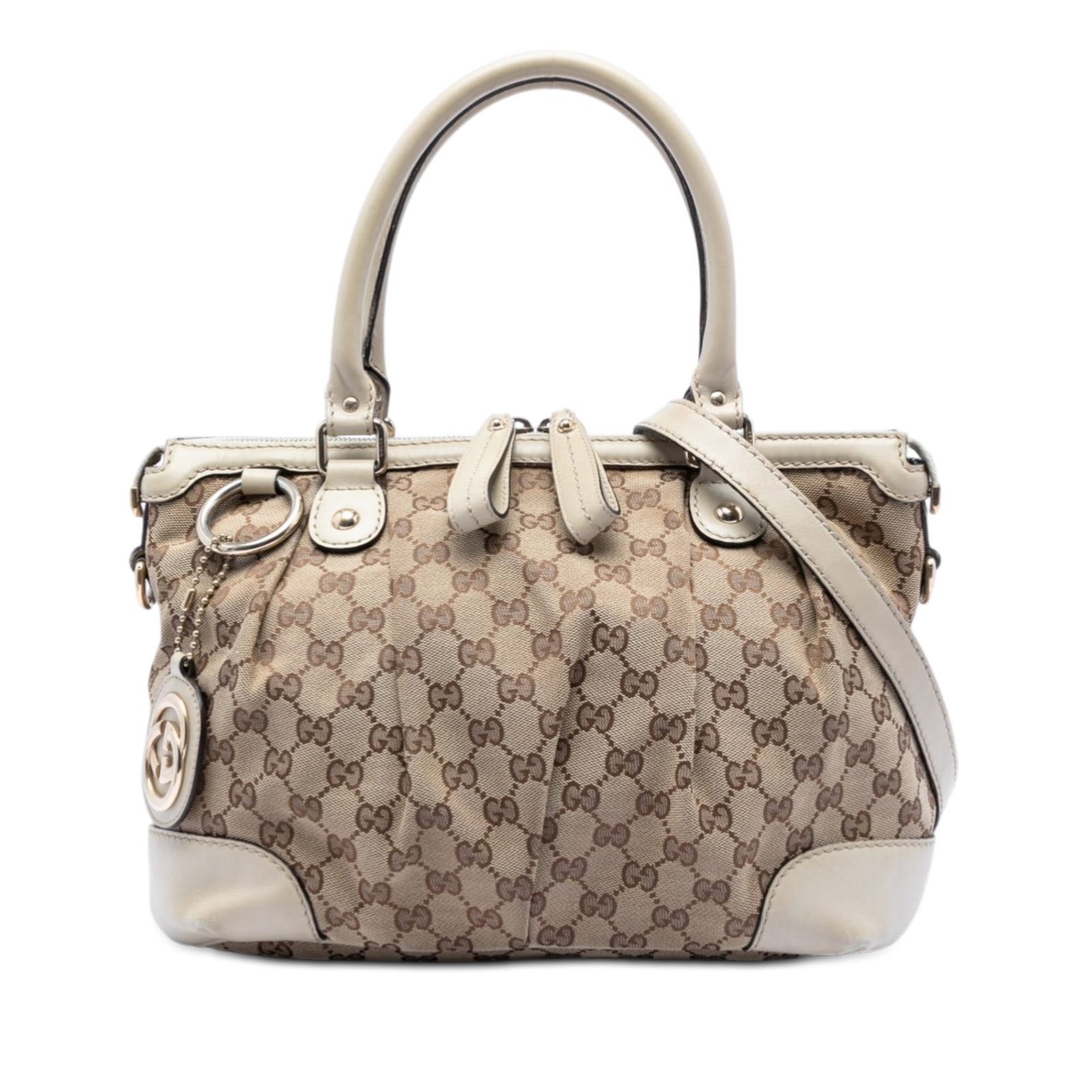 Gucci Sukey Beige GG Canvas Satchel with Leather Trim and Strap: Gucci Sukey Beige GG Canvas Satchel with Leather Trim and Strap The Gucci GG Canvas Sukey Satchel showcases a beige canvas body with leather trim, rolled leather handles, and a detachable, adjustable 