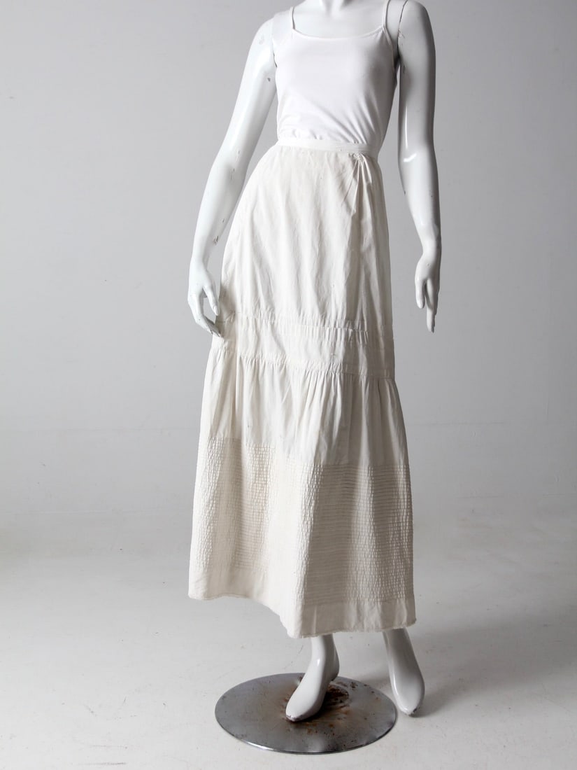 Vintage Antique Cotton Petticoat Skirt with Lace Trim: Vintage Antique Cotton Petticoat Skirt with Lace Trim This exquisite antique petticoat skirt dates back to the late 1800s to early 1900s, showcasing timeless elegance. Crafted from white cotton, it fe