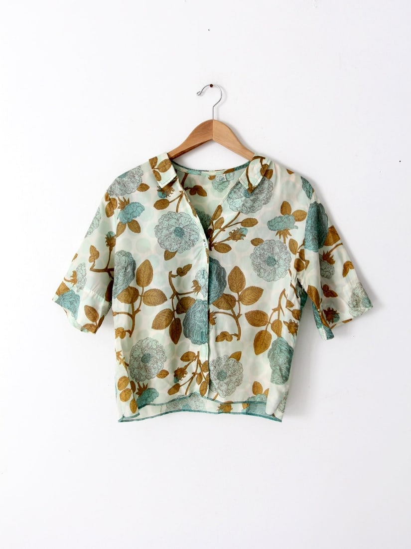 1950s Vintage Silk Blouse Turquoise Gold Floral Union Labeled: 1950s Vintage Silk Blouse Turquoise Gold Floral Union Labeled This vintage 1950s silk blouse showcases a beautiful turquoise and gold floral pattern. The shirt features a button-up design with half sl