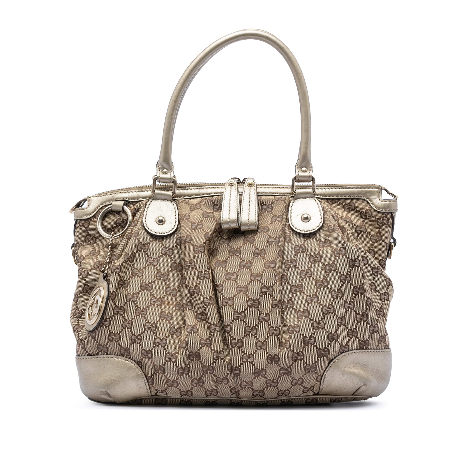Beige GG Canvas Sukey Satchel Bag with Leather Trim by Gucci: Beige GG Canvas Sukey Satchel Bag with Leather Trim by Gucci This Gucci GG Canvas Sukey Satchel features a beige canvas body with leather trim and rolled leather handles. It is designed with a top zip