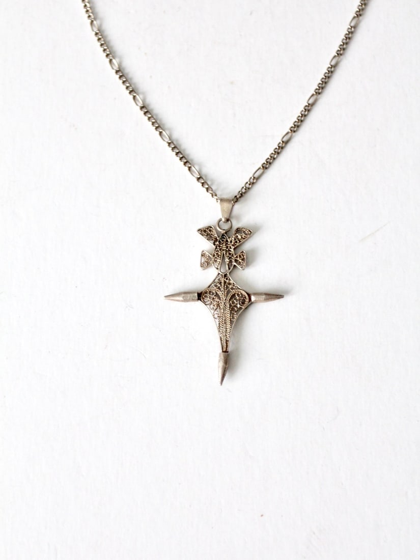 Vintage Silver Tone Filigree Cross Necklace 20 Inch Chain: Vintage Silver Tone Filigree Cross Necklace 20 Inch Chain This vintage filigree cross necklace showcases a striking silver tone pendant crafted with intricate filigree design and spiked ends. It is el
