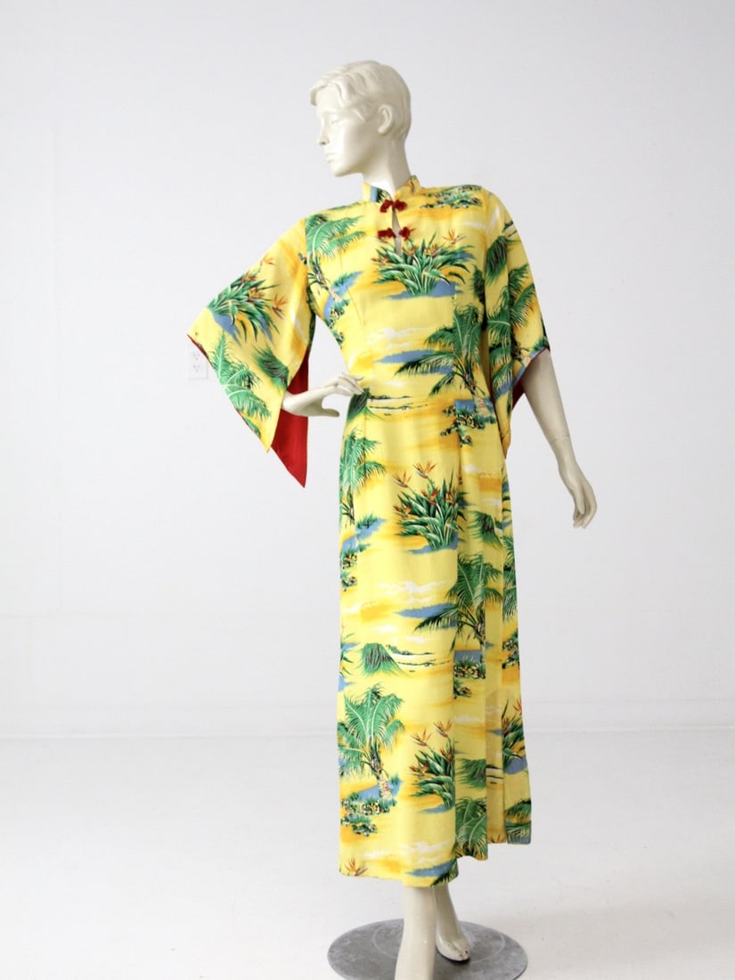 1950s Hale Hawaii Rayon Kimono Dress Yellow Landscape Print: 1950s Hale Hawaii Rayon Kimono Dress Yellow Landscape Print Introducing a charming vintage 1950s Hale Hawaii dress, perfect for those who appreciate classic style. This fitted kimono-style dress is ma