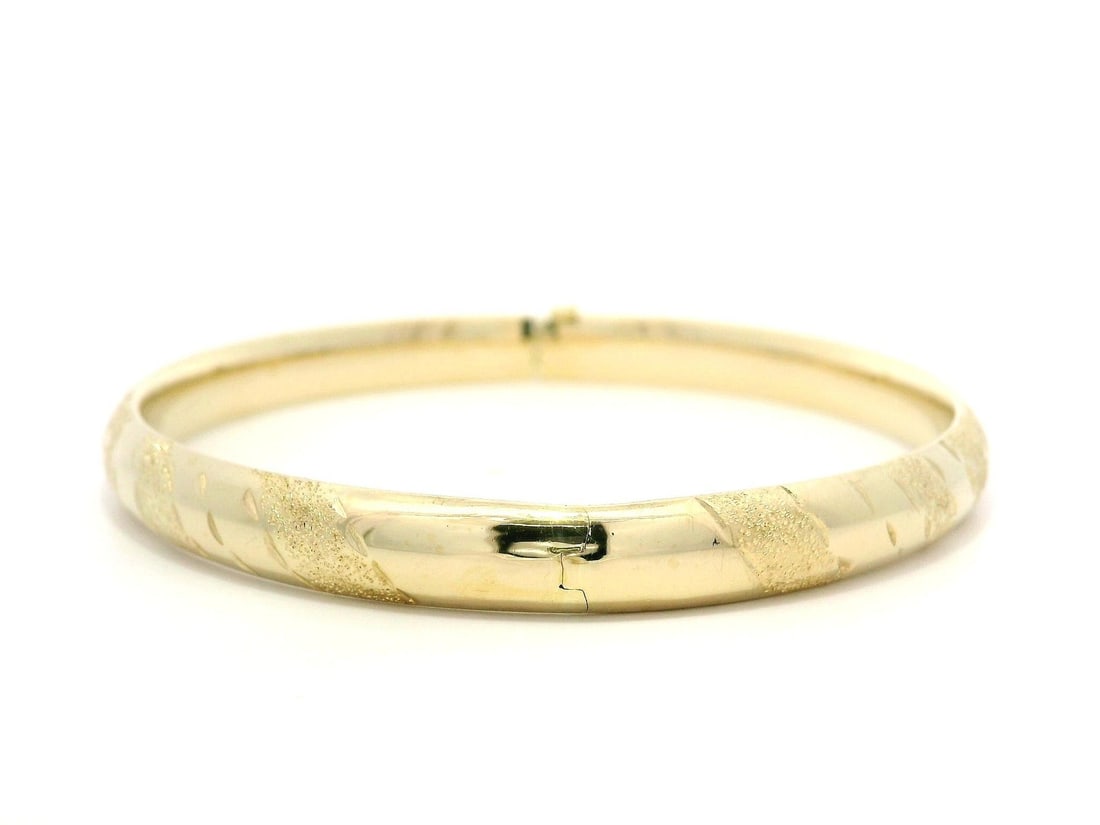 14k Yellow Gold Diamond Cut Hinged Bangle Bracelet 6.2mm: 14k Yellow Gold Diamond Cut Hinged Bangle Bracelet 6.2mm This exquisite 14k Yellow Gold Diamond Cut Polished Open Hinged Bangle Bracelet features a stunning hollow design. Weighing 7.40 grams, this br