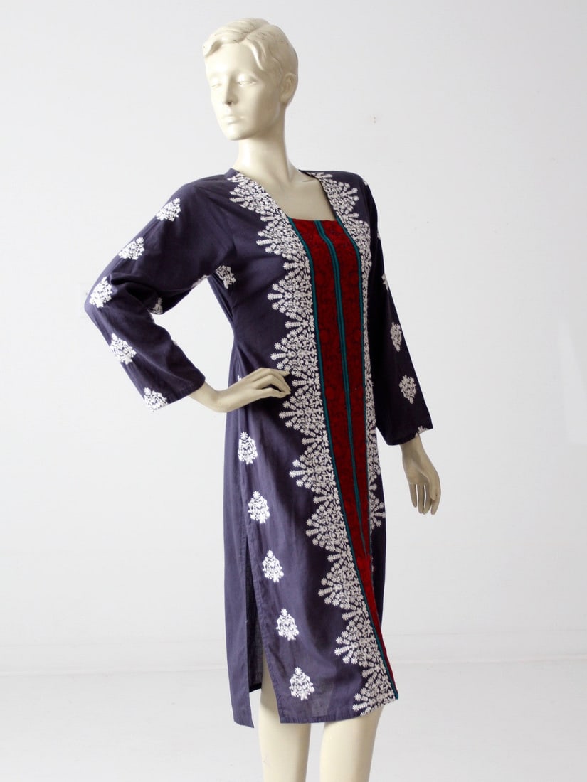 Vintage 1970s Navy Cotton Tunic Dress with Embroidery: Vintage 1970s Navy Cotton Tunic Dress with Embroidery This stunning vintage 1970s tunic caftan dress features intricate embroidery in white, red, and turquoise on a lightweight navy cotton fabric. Wit