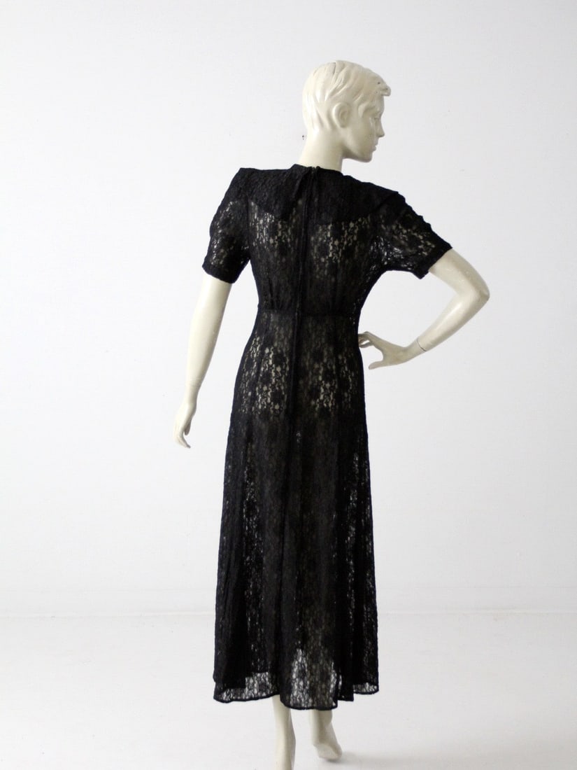 1970s Vintage Black Lace Maxi Dress with Floral Pattern: 1970s Vintage Black Lace Maxi Dress with Floral Pattern This stunning vintage 1970s black lace maxi dress showcases a delicate floral pattern throughout the lace fabric. Featuring a pleated bust and a