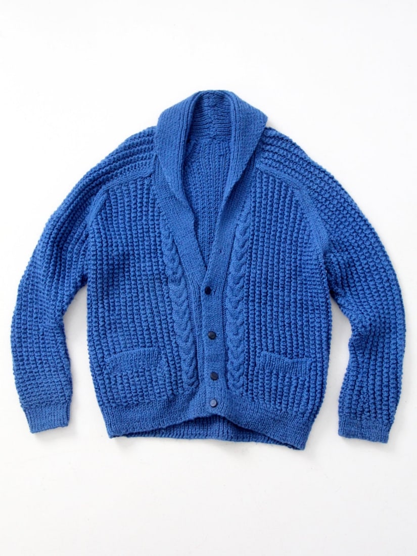 Vintage Royal Blue Hand-Knit Cardigan with Pockets: Vintage Royal Blue Hand-Knit Cardigan with Pockets This vintage hand-knit shawl collar cardigan is a stylish piece in a chunky royal blue knit. Featuring button closures and practical front waist pock