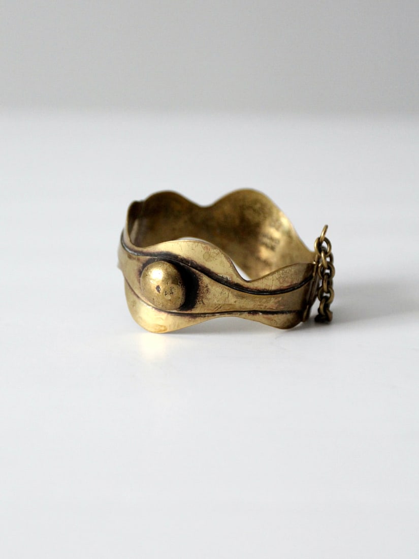 1960s Seppo Tamminen Bronze Cuff Bracelet Handmade Finland: 1960s Seppo Tamminen Bronze Cuff Bracelet Handmade Finland Discover a stunning 1960s bronze bracelet by renowned designer Seppo Tamminen. This hand-wrought hinged cuff features a captivating ancient F
