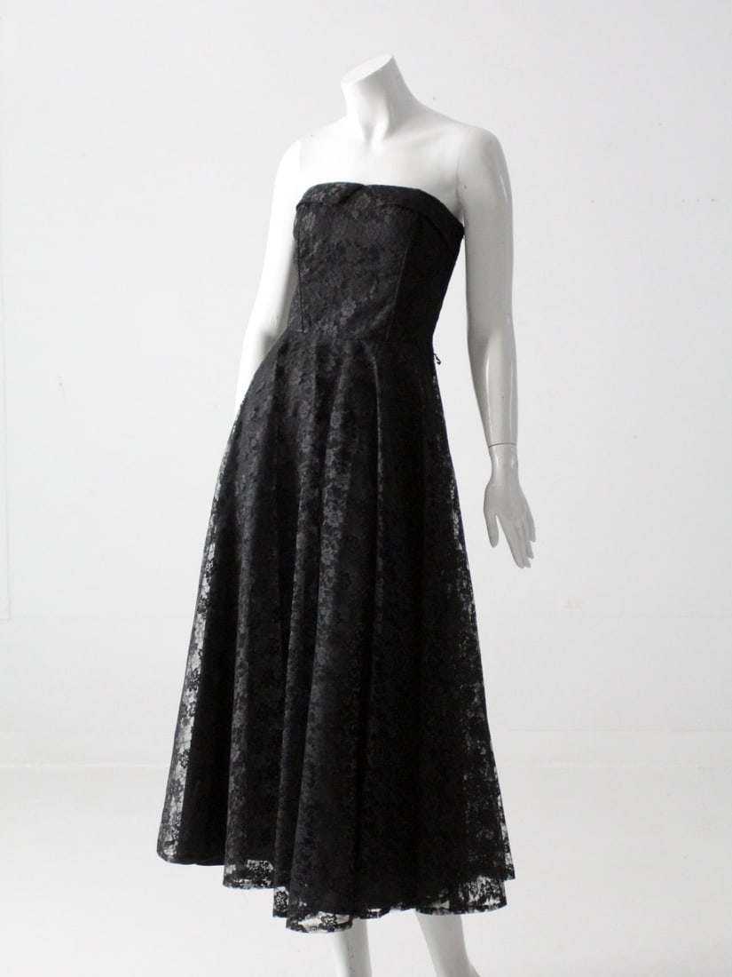 Vintage 90s Boutique Europa Black Lace Strapless Midi Dress: Vintage 90s Boutique Europa Black Lace Strapless Midi Dress Step into a world of vintage elegance with this stunning 90s black lace strapless dress from Boutique Europa. This fit and flare midi-length