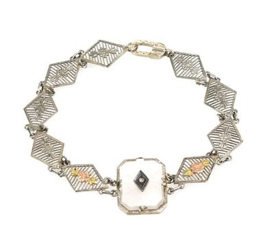 14k Tri Color Gold Camphor Glass Diamond Bracelet: 14k Tri Color Gold Camphor Glass Diamond Bracelet This authentic vintage bracelet is crafted from 14k rose, yellow, and white gold, showcasing a refined interplay of tri-color metals. The design featu
