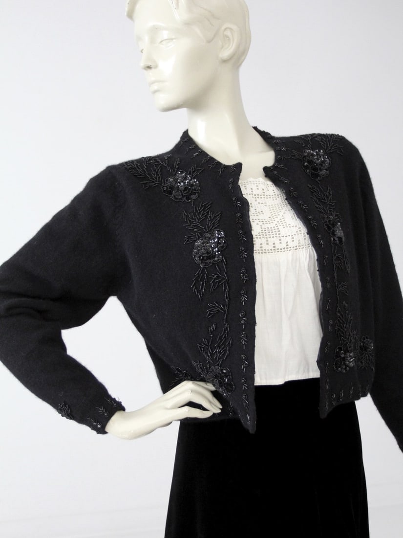 Vintage Black Beaded Cardigan Sweater Lambswool Angora: Vintage Black Beaded Cardigan Sweater Lambswool Angora This vintage beaded cardigan sweater is a stunning piece made from a luxurious blend of black lambswool and angora wool. It features intricate be