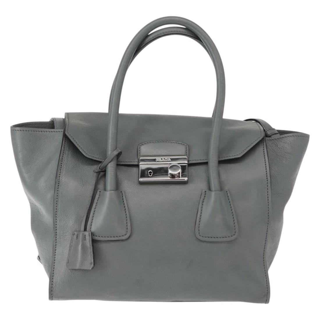 Prada Twin Pocket Lock Flap Leather Tote Bag in Gray: Prada Twin Pocket Lock Flap Leather Tote Bag in Gray The Prada Twin Pocket Lock Flap Tote in gray leather is a sophisticated handbag designed for women. Crafted in Italy, this tote features a structur