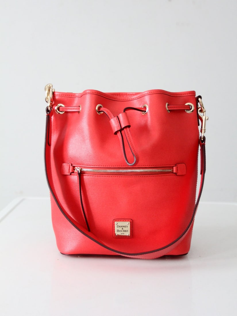 Dooney & Bourke Red Saffiano Drawstring Bucket Bag with Gold-tone Hardware: Dooney & Bourke Red Saffiano Drawstring Bucket Bag with Gold-tone Hardware Make a bold statement with this Dooney & Bourke Saffiano Drawstring Bag in rich red leather. Crafted from durable Saffiano le