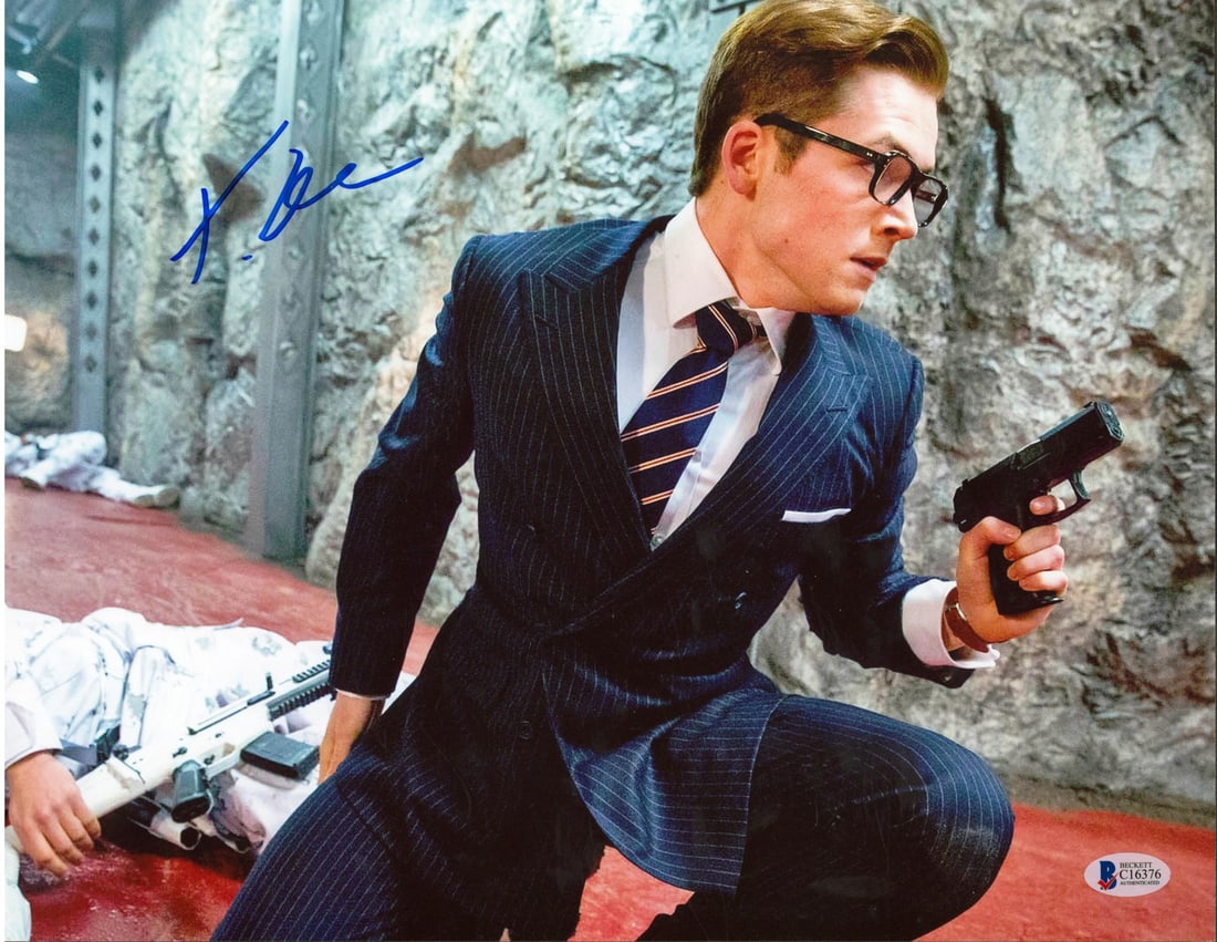 Taron Egerton Autographed 11x14 Kingsman Photo with Beckett COA: Taron Egerton Autographed 11x14 Kingsman Photo with Beckett COA This stunning 11x14 photograph features Taron Egerton, personally signed for fans of 'Kingsman: The Secret Service.' This original item 