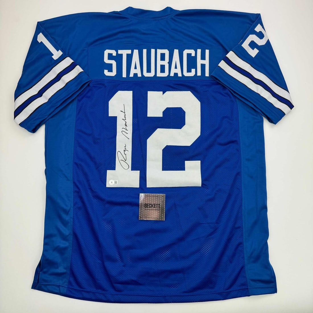 Roger Staubach Signed Custom Dallas Blue Jersey Beckett Authenticated: Roger Staubach Signed Custom Dallas Blue Jersey Beckett Authenticated This is a custom Dallas blue football jersey autographed by Roger Staubach. The jersey features the player's name and number but d